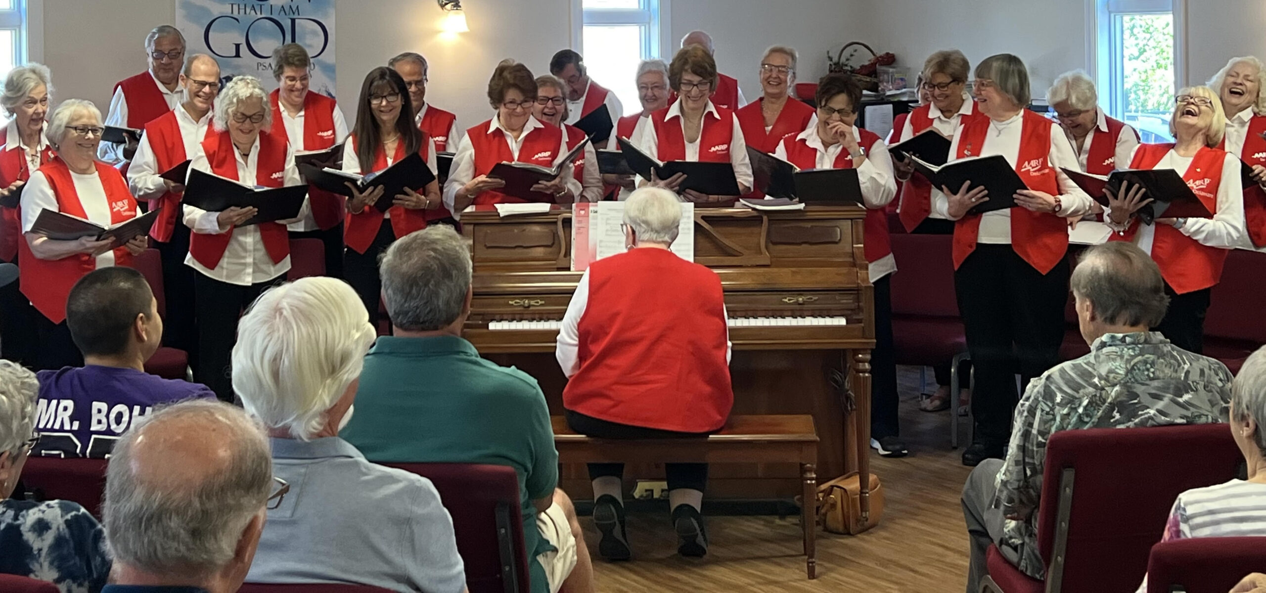 The Singers of Note, under the direction of Ann Jaeger, enjoy a light-hearted moment at a spring concert.